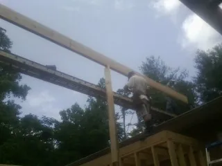 Carpenter setting a ridge beam over a new addition frame — Ice Dam Removal by Roofing Brothers in Weatogue