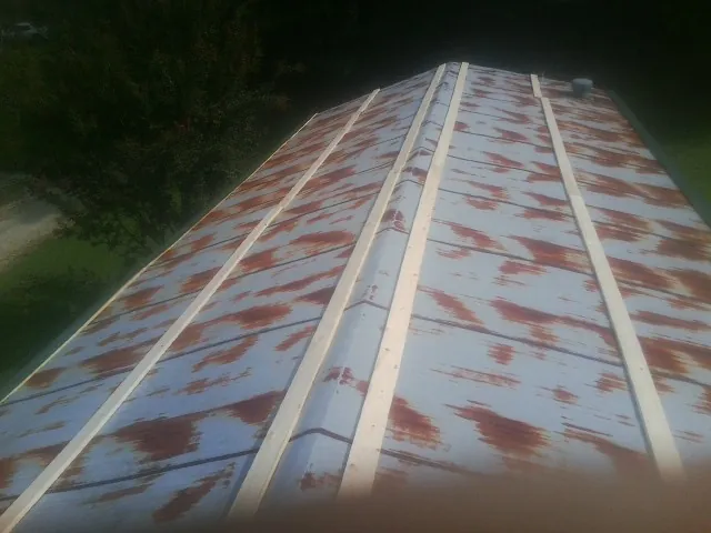 Rusted metal roof panels with new wood purlins before replacement — Storm Damage Roof Repair in Weatogue by Roofing Brothers