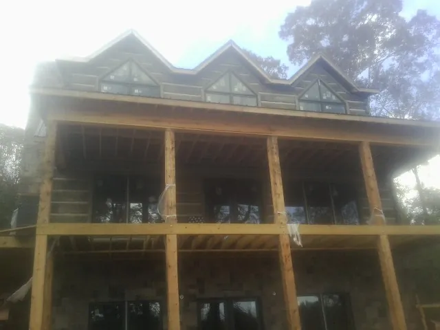 Dormers and porch framing on a large log home under construction — Roof Coating work by our crew in Weatogue