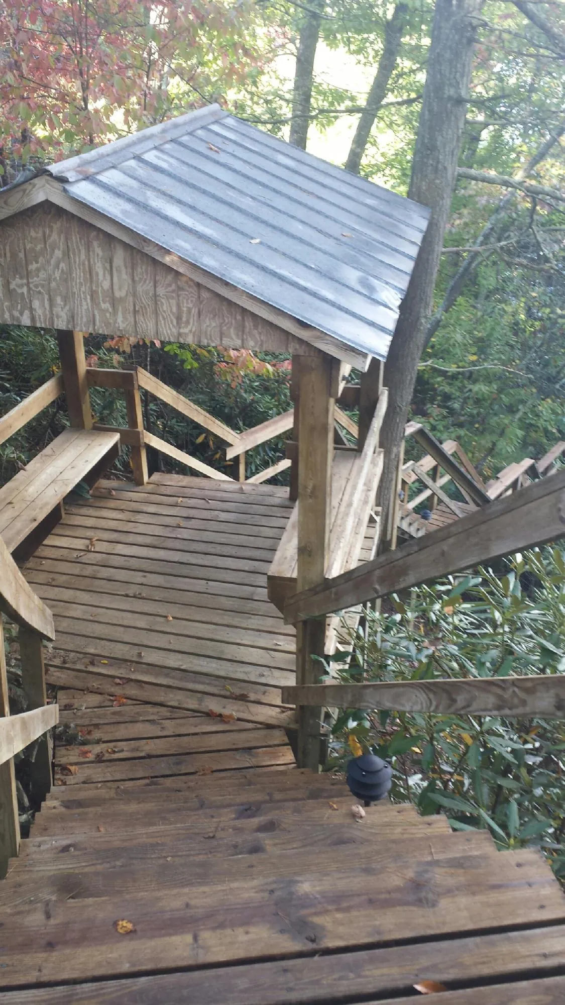 Metal roofed shelter over wooden steps on a wooded walkway — Skylight Repair & Installation work by our crew in Weatogue